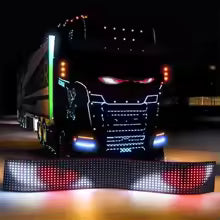 A black semi-truck at night features the Smart LED Pixel Panel – Light Up Your Space with Custom Animations, displaying glowing eyes and dynamic patterns on its front for an animated, fierce look with Bluetooth-enabled lighting effects.